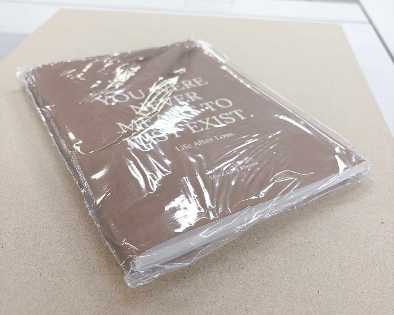Example of an unbound proof for a perfect bound book, with the cover folded around the book block and shrink-wrapped for protection.