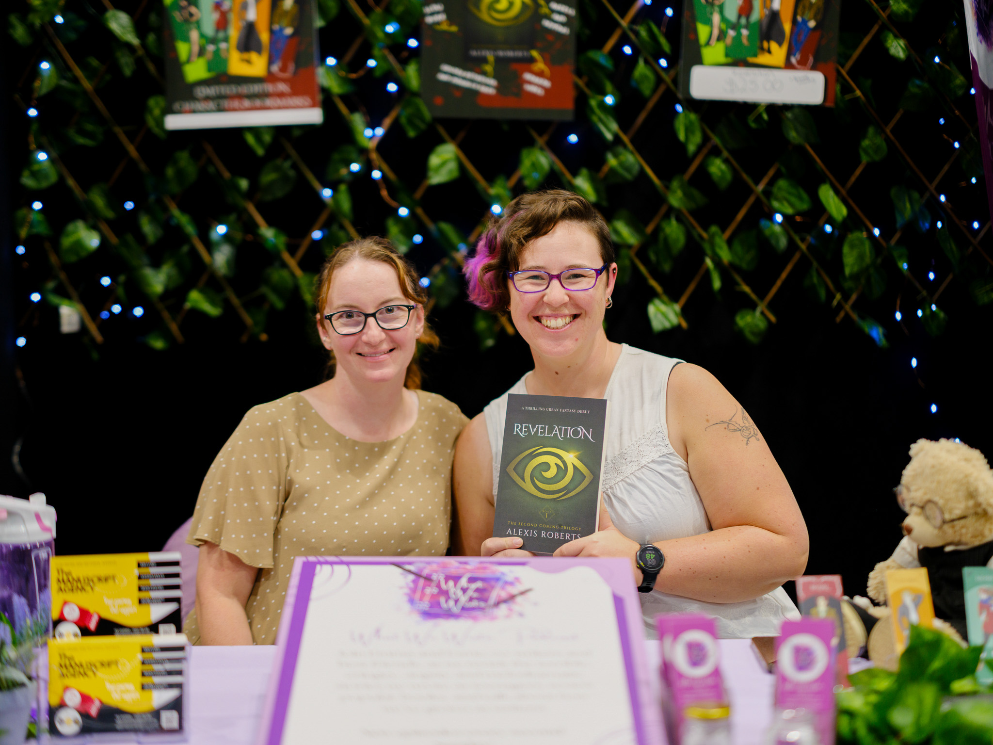 Emma and Esme, aka Alexis Roberts, at Book Fair Australia (2026) with their debut novel, Revelation. Courtesy of Alexis Roberts, image by Golden Wing Press.