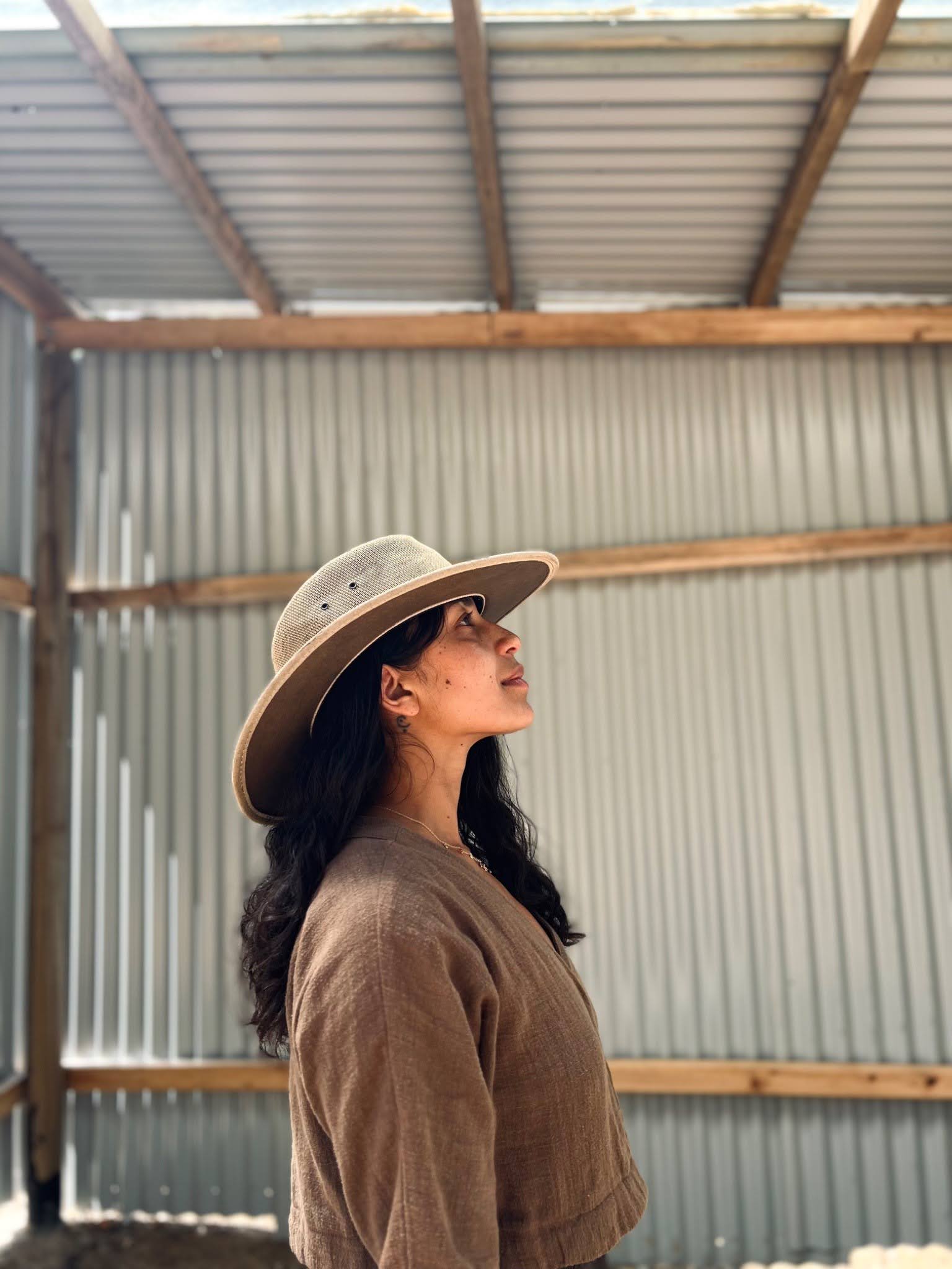 Saara Milliken, author of A Flower State of Mind, side profile portrait short with a film camera. Courtesy of Saara Milliken.