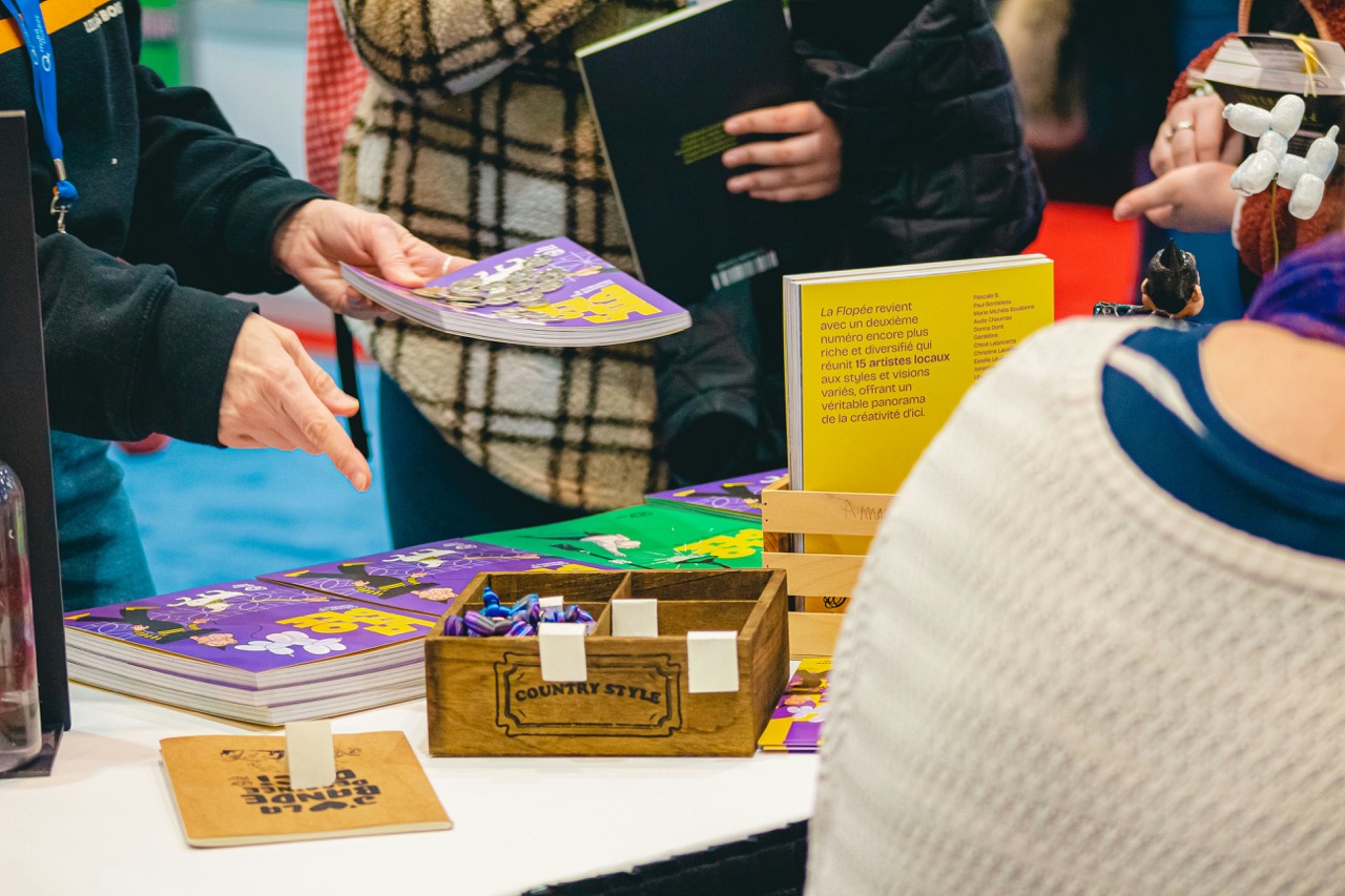 Author selling their books at a book fair. Image source: Compagnons on Unsplash
