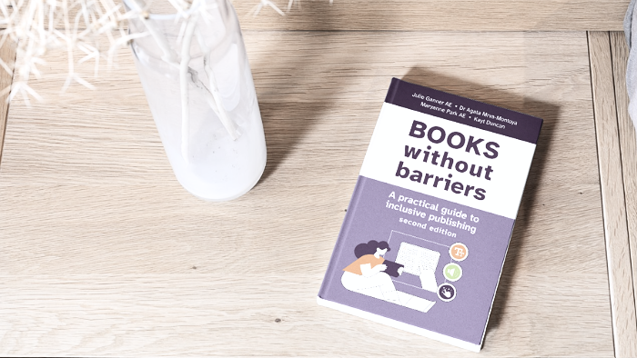 Copy of Books without Barriers on a table next to a vase. Source: Institute of Professional Editors Limited (IPEd).