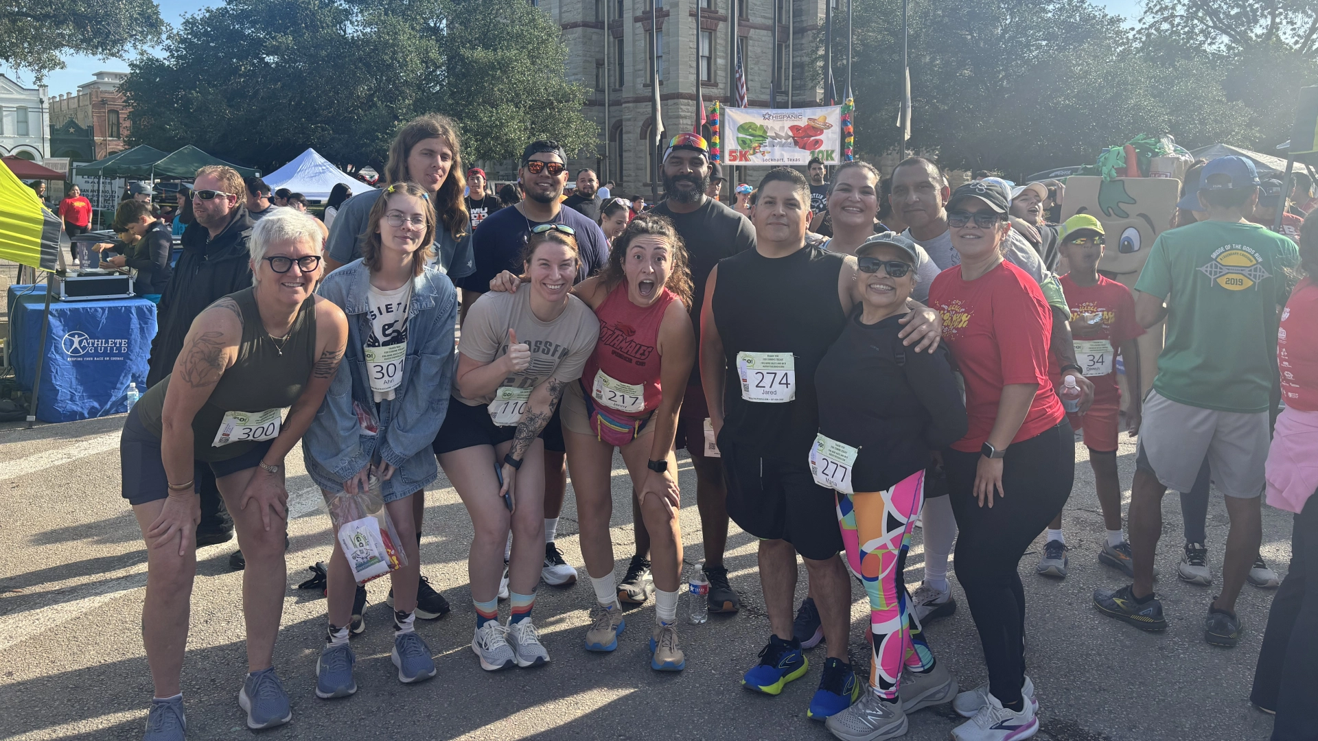 A group of people smiling and posing for a photo after a race at On The Block Fitness in Lockhart, TX.