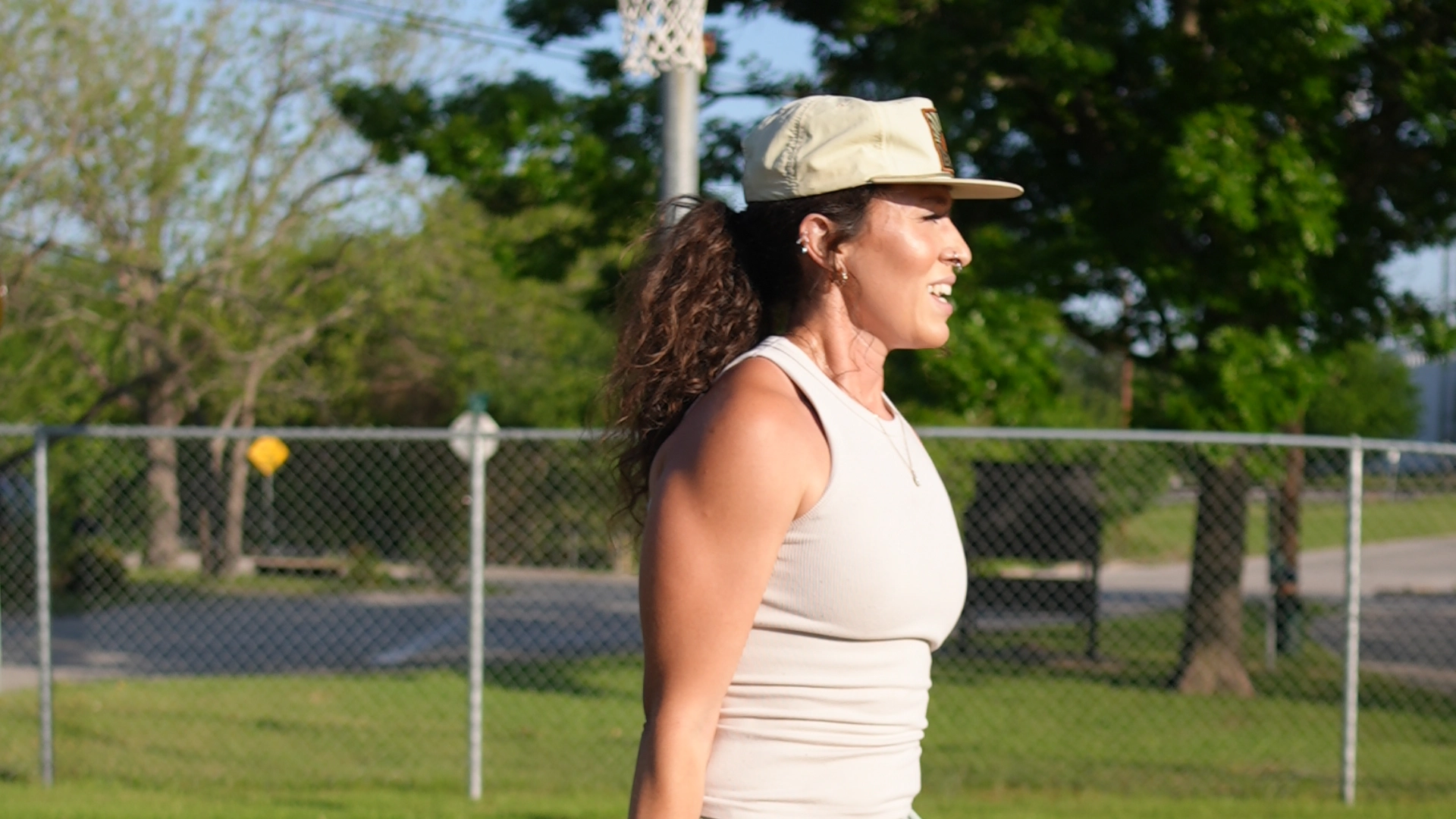 A woman stands holding a tennis racket, promoting On The Block Fitness in Lockhart, TX.