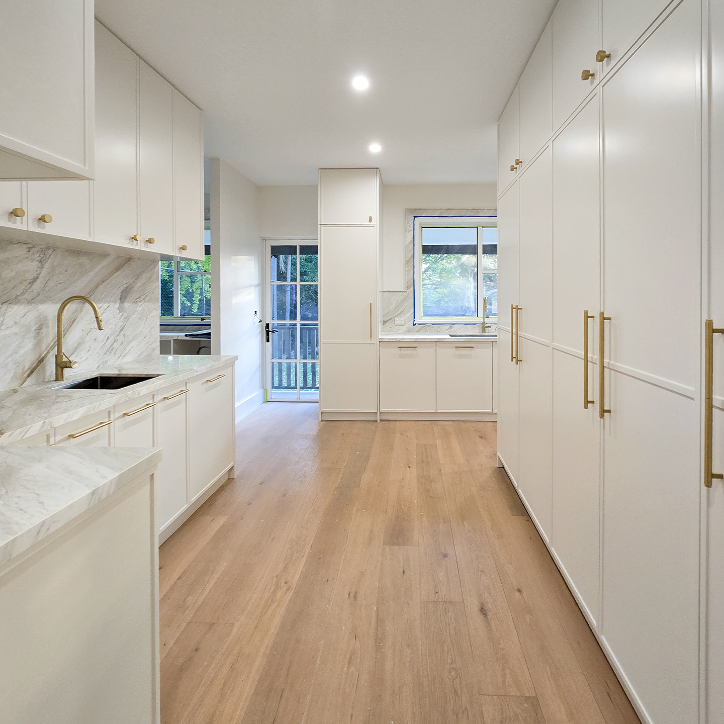 The view through to the butler's pantry. Same stone, same joinery, carried across all three zones