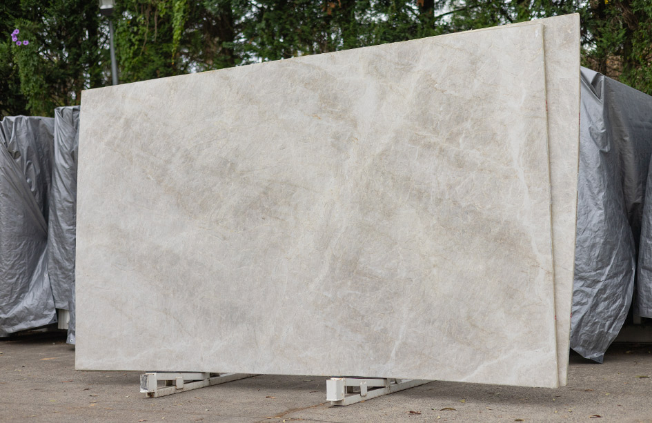 Large taj mahal quartzite slab resting outdoors, ready for fabrication into premium stone benchtops sydney