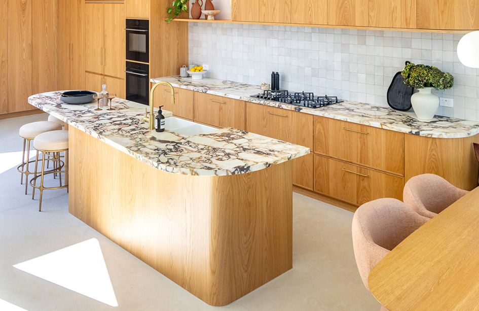 Curved Calacatta Viola marble island with cantilevered overhang on a timber column, burgundy veining, gold stools, timber joinery, Sydney kitchen by Marble Hub