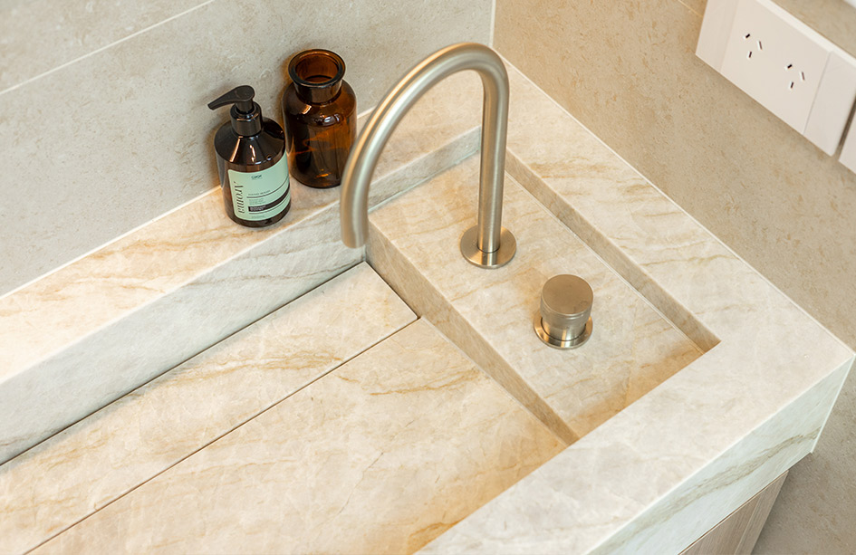 The integrated basin up close: the fall, the drain channel and the stone pop-up waste, cut from the same Taj Mahal Quartzite slab. Marble Hub install, Sydney.