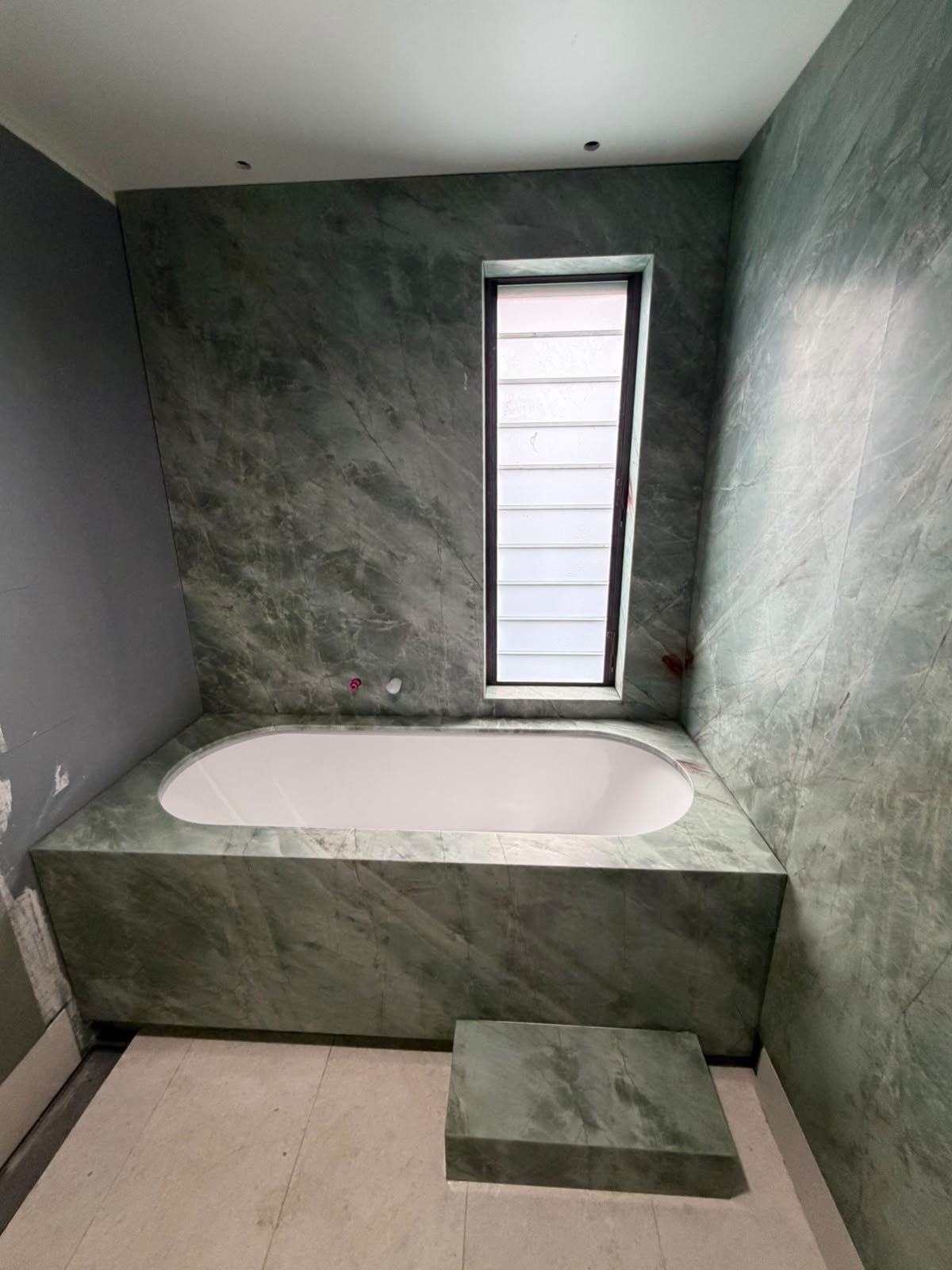 Esmeralda quartzite bath surround with full Esmeralda quartzite walls and a matching stone step, undermount bath, Sydney bathroom.