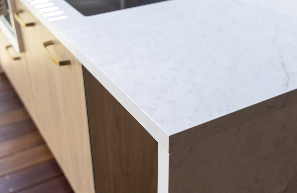 Outdoor BBQ area showcasing a durable Everest Sunrise Silk Neolith Porcelain benchtop. The UV-stable, heat-proof surface features a precise undermount stainless steel sink cutout and integrates seamlessly with the grill.