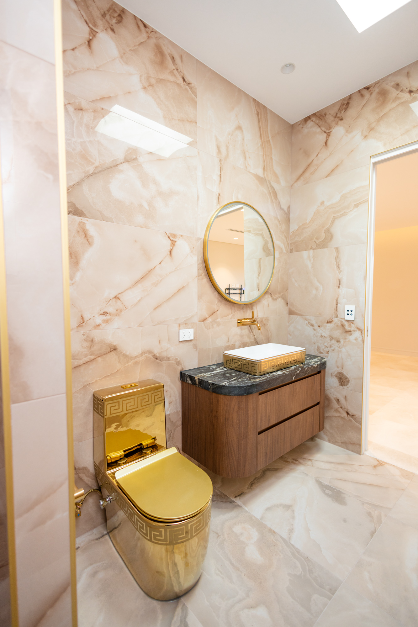 Deep green Arabescato Grigio Orobico marble vanity top, walnut joinery, gold basin, Sydney