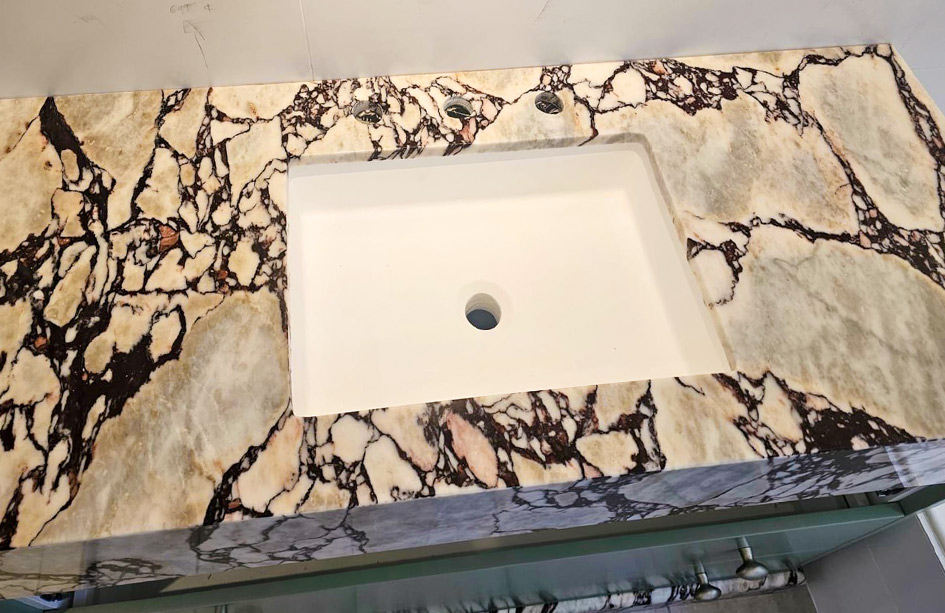 Calacatta Viola marble vanity, top-down view, violet and burgundy veining, undermount basin