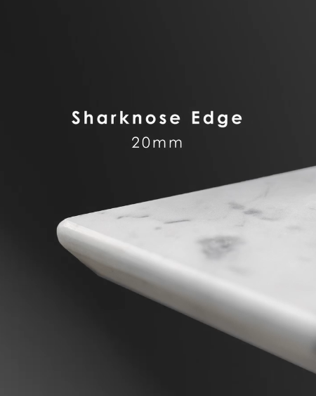 Sharknose 20mm edge on a marble benchtop, angled undercut cutting a shadow line beneath the top.