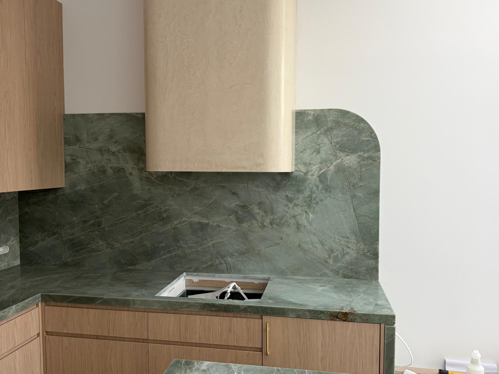 Curved emerald green quartzite splashback with light oak joinery in a Sydney kitchen