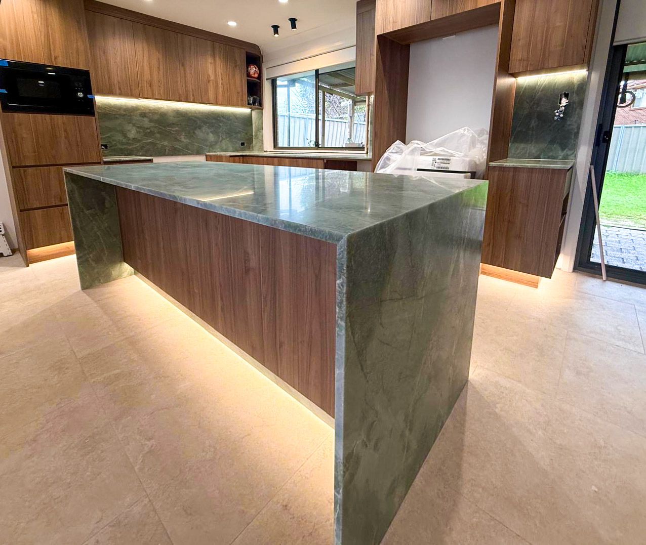 Esmeralda emerald green quartzite kitchen benchtop and full slab splashback paired with walnut joinery in a Sydney home