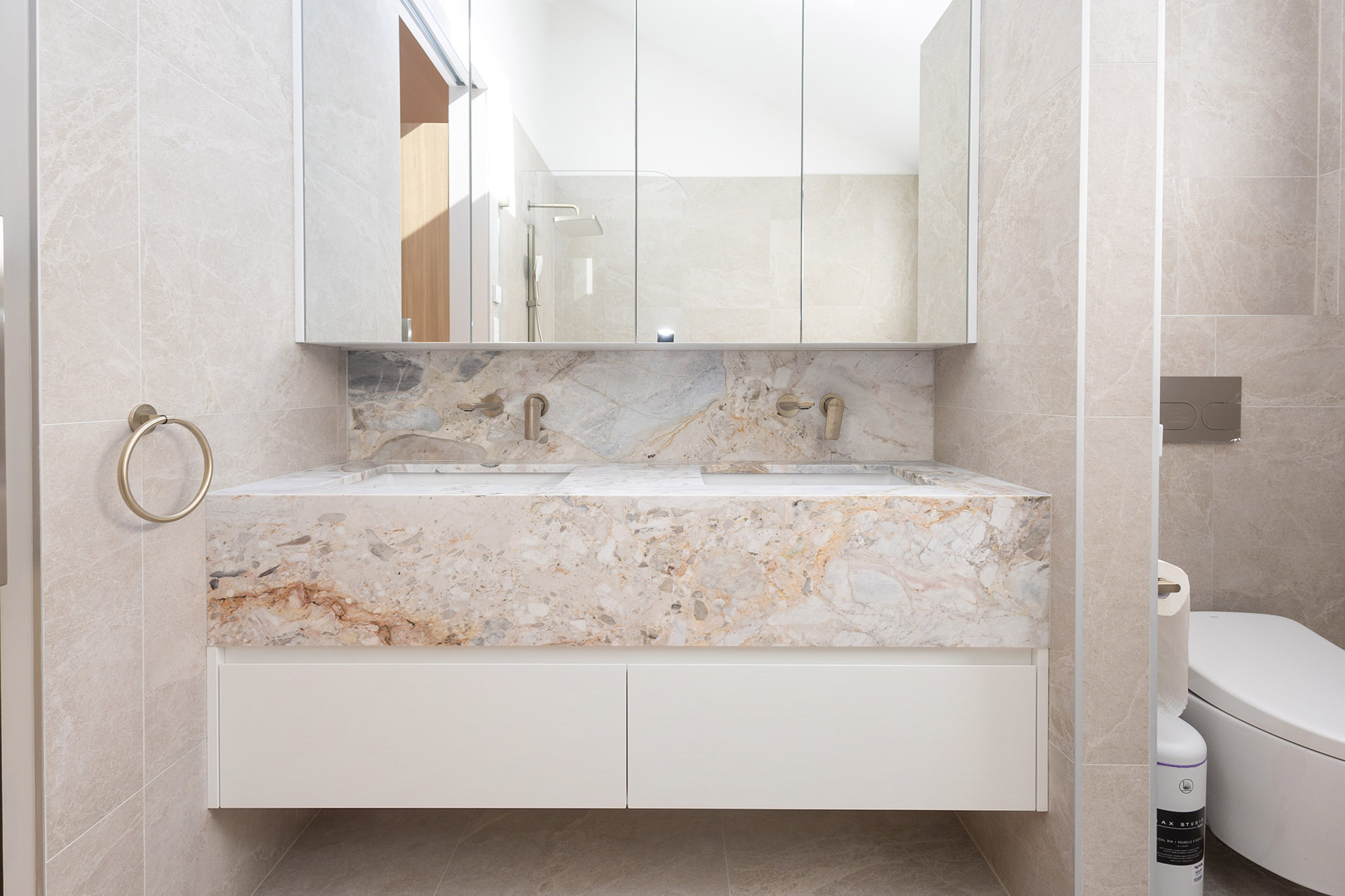 Aurora Milano brecciated stone double vanity with a stone apron front, undermount basins and wall-mounted brass taps, Randwick bathroom, Sydney