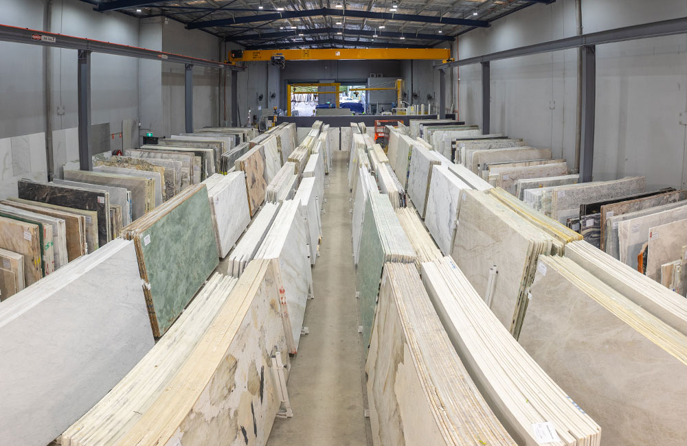 Comparing full natural stone slabs during a benchtop decision in a Sydney showroom
