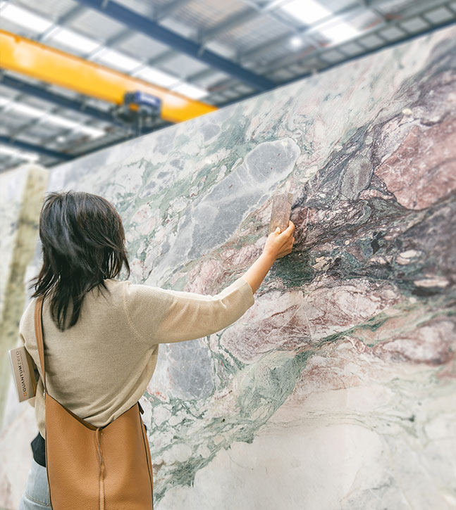 Comparing full natural stone slabs during a benchtop decision in a Sydney showroom