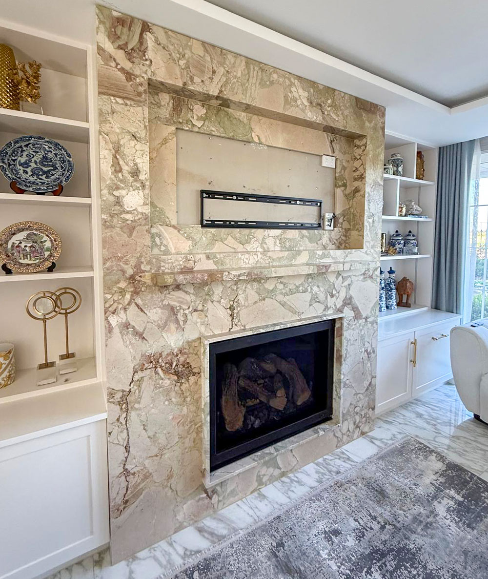 Recessed television and stone ledge on a Breccia fireplace, full-slab front with discreet joins, Marble Hub Sydney