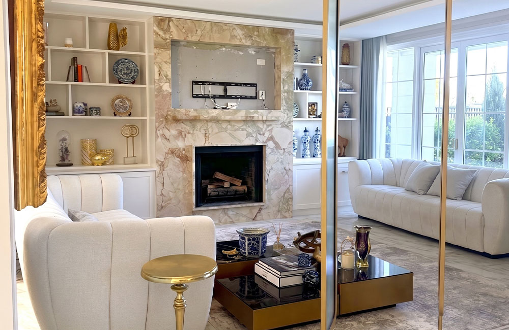  Breccia stone fireplace running the full front of the column, framing a recessed television and gas firebox, flanked by white joinery, Sydney living room by Marble Hub