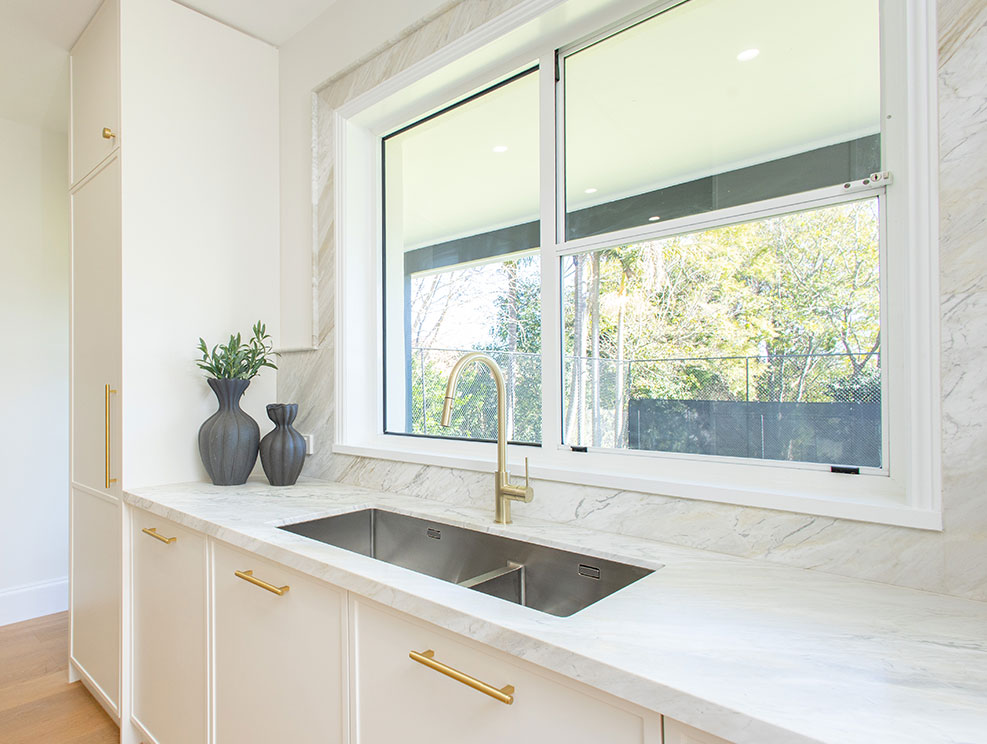 Marble splashback around a kitchen window with a mitred stone sill, Sydney