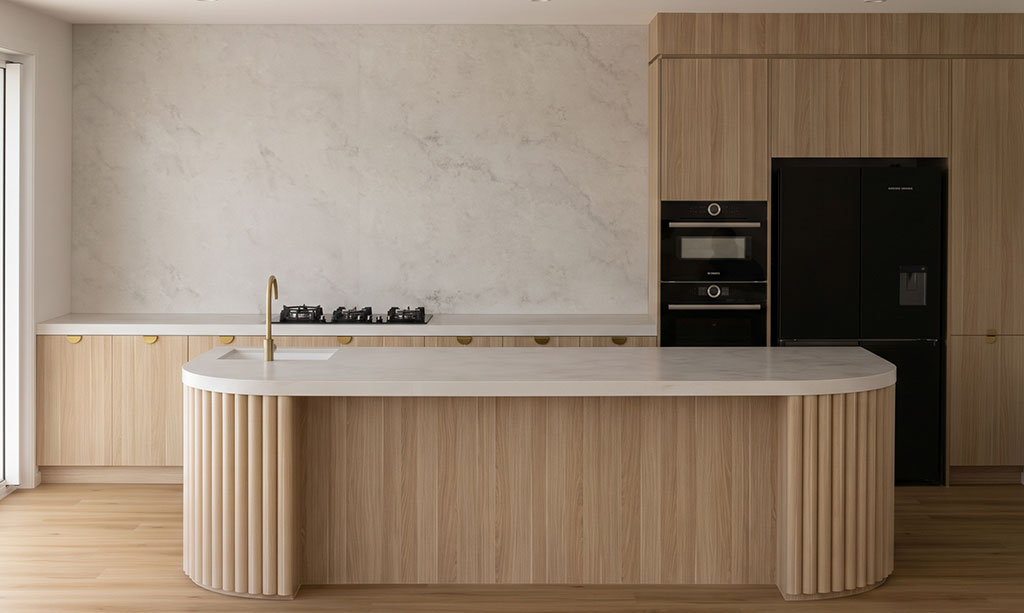 Engineered stone full slab splashback continuing benchtop veining up the wall, Sydney kitchen 