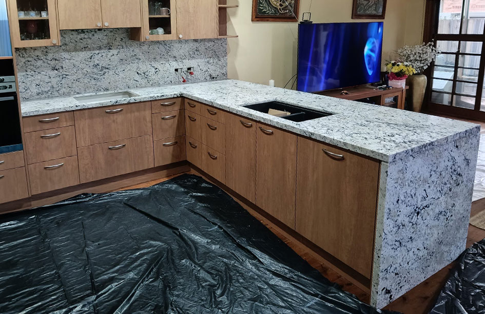 White granite outdoor kitchen with full slab splashback and black cabinetry, Sydney