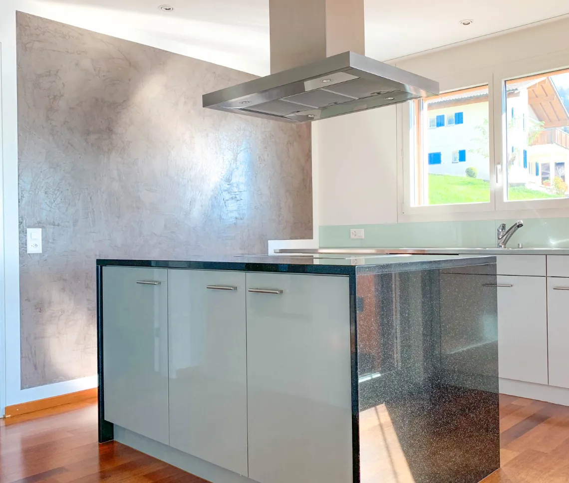 Moderne Einbauküche in der Maisonette-Wohnung mit Herd und Dunstabzugshaube.