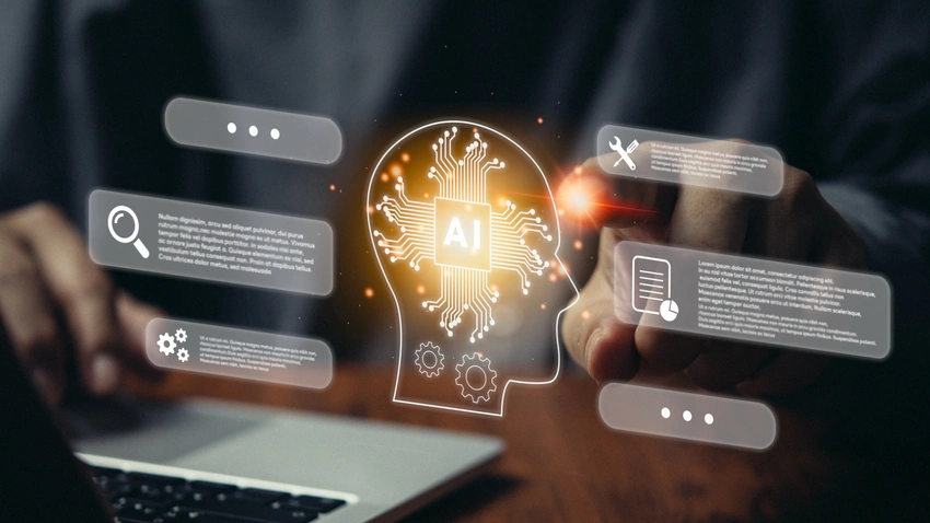 A futuristic humanoid robot working at a computer, representing an AI agent