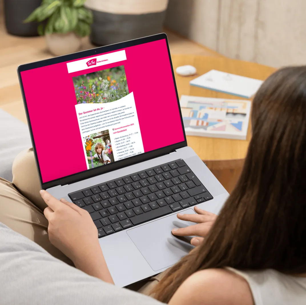 Eine Frau sitzt am Laptop und liest einen TeeFee Artikel