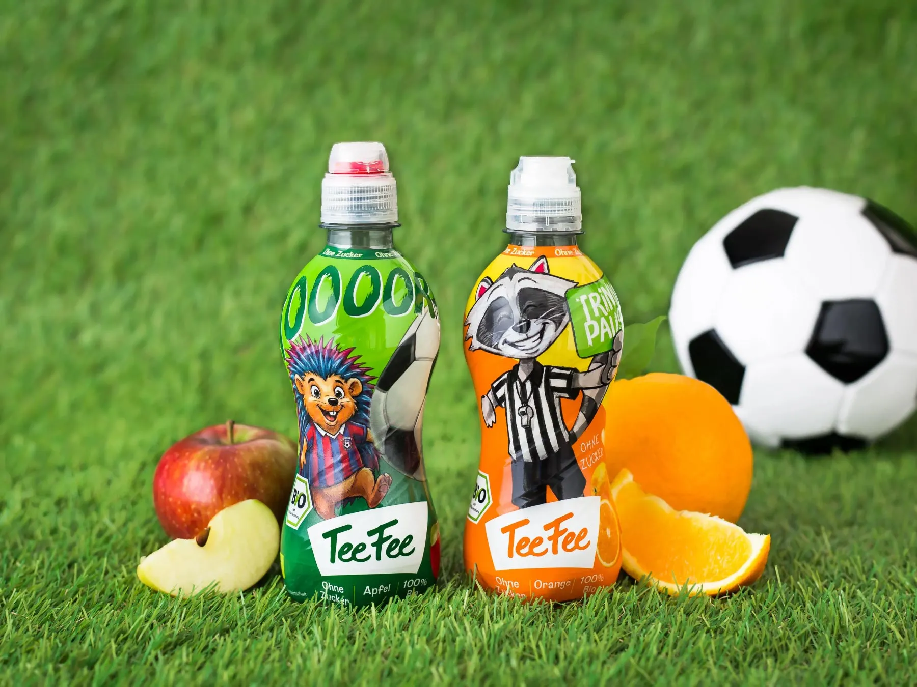 TeeFee Apfel und Orange Fußballedition auf einem Fußballplatz