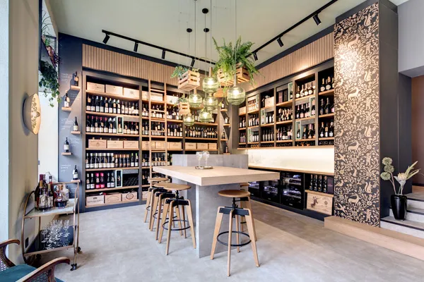 Modern eingerichtetes Weinatelier mit Holzregalen, stilvoller Beleuchtung und gemütlicher Sitzecke – exklusive Vinothek mit hochwertiger Innenarchitektur.