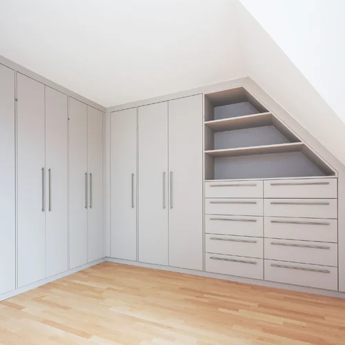 Maßgefertigter Einbauschrank in heller Optik mit Schranktüren, Schubladen und offenen Regalfächern unter einer Dachschräge.