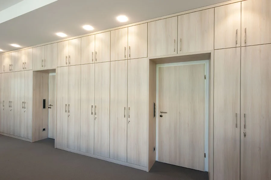 Büroeinbauschränke in heller Holzoptik mit durchgängiger Frontgestaltung und integrierten Türen für maximale Stauraumnutzung.