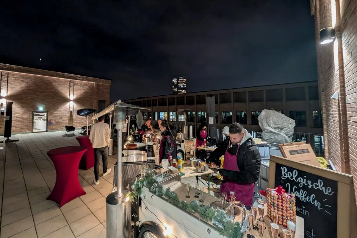 Firmenfeier am Abend: Dachterrasse mit Stehtischen, Sekt und Live-Cooking-Station