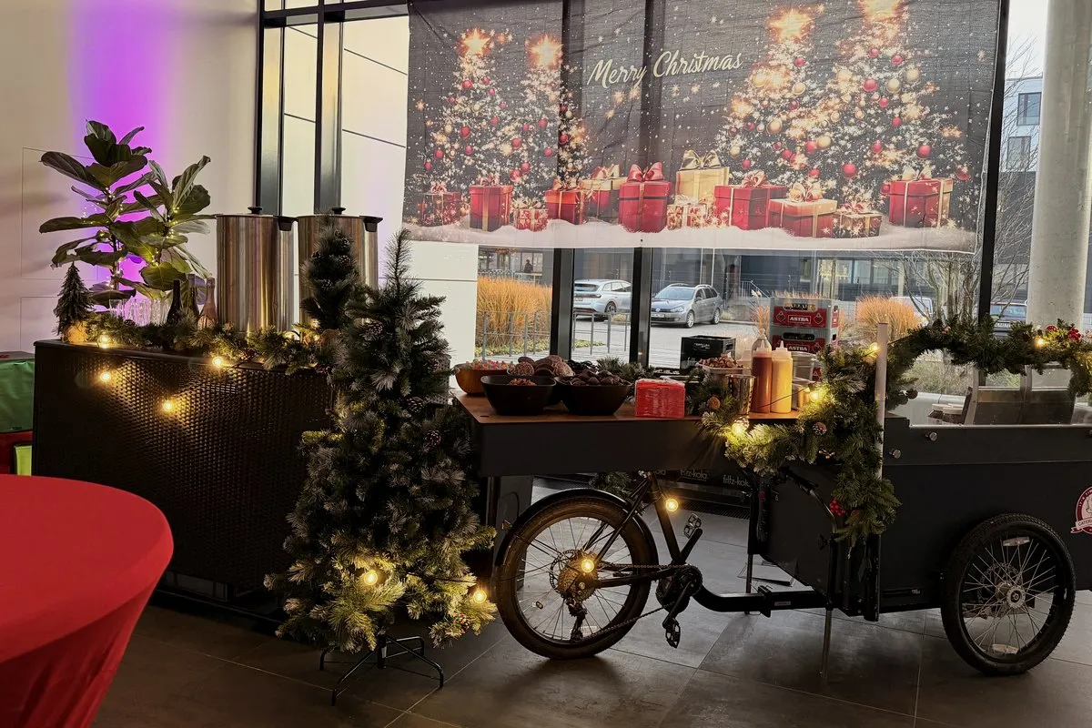 Weihnachtsfeier: geschmücktes HappyBike mit Tannengrün und Lichterketten im Foyer