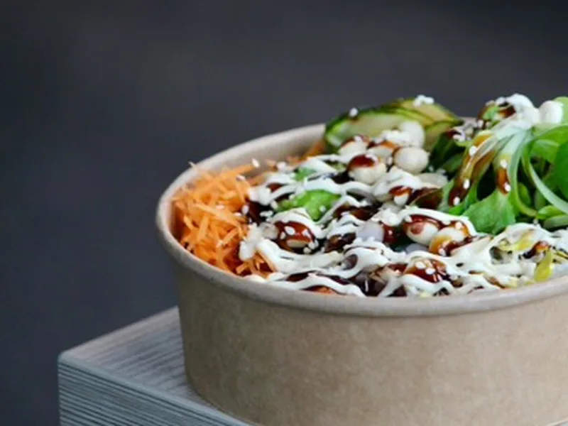 Frisch angerichtete Bowl mit Karotten, Gurke und Sesam