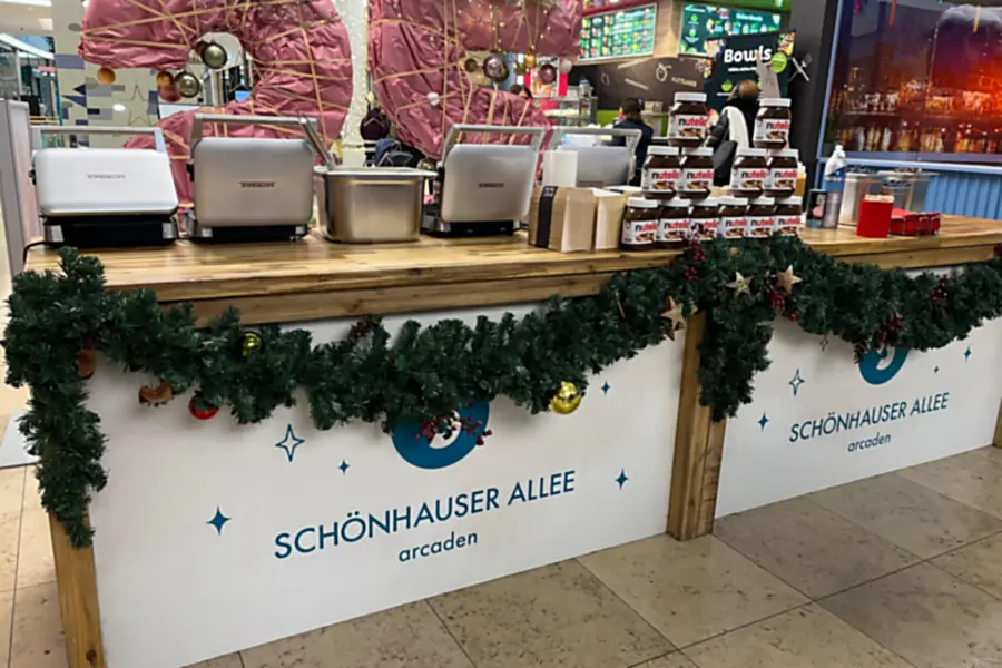 Ausgabetheke einer Live-Cooking-Station in den Schönhauser Allee Arcaden in Berlin, mit Waffeleisen und weihnachtlich geschmückter Front