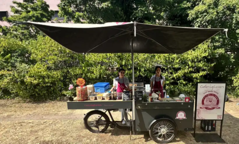 HappyBike-Getränkestation unter schwarzem Sonnenschirm im Grünen