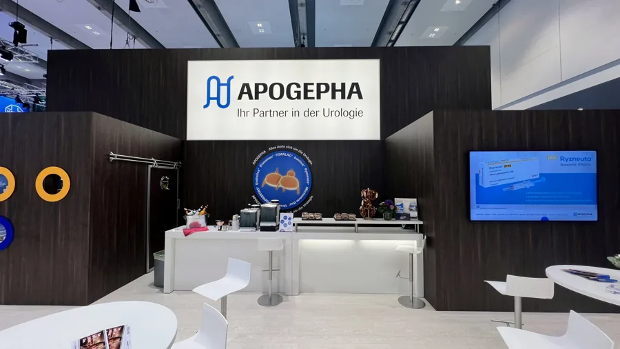 Messestand mit integrierter Catering-Theke, Barhockern und Screens unter dem Apogepha-Schriftzug