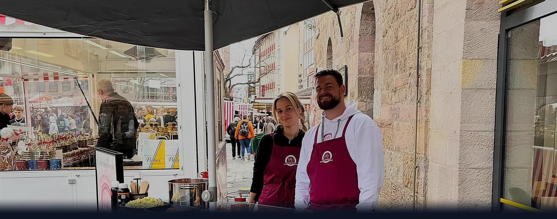 PoS-Aktion in der Fußgängerzone: zwei CateringLovers-Gastgeber am HappyBike unter dem Schirm, Passanten im Hintergrund.