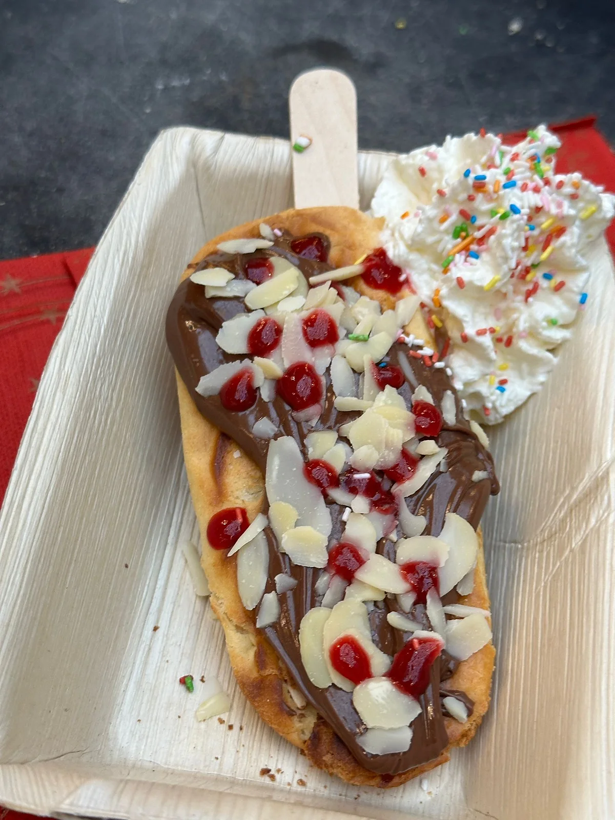 Frisch gebackene Waffel am Stiel mit Schokolade und Toppings
