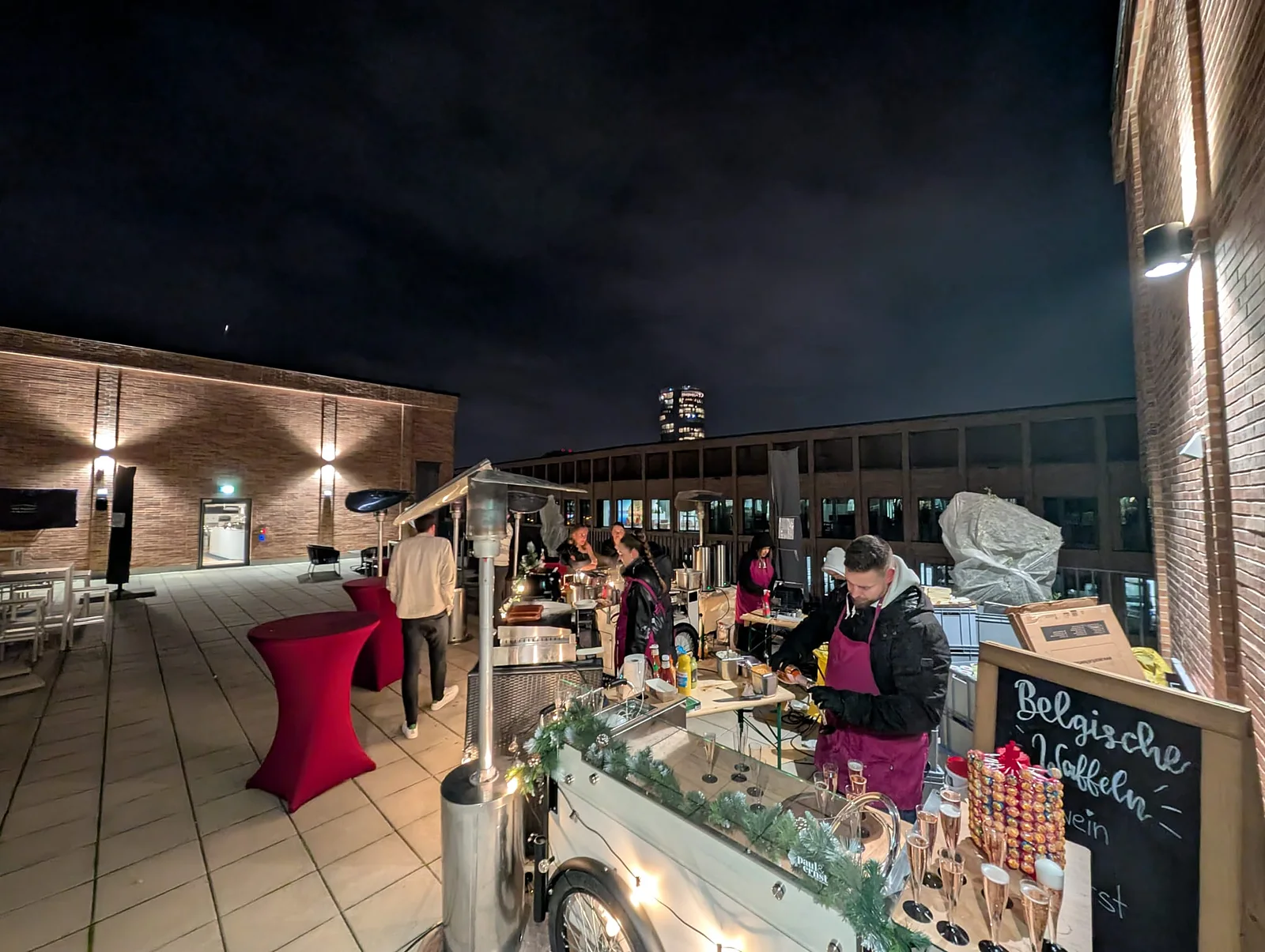 Live-Cooking-Station auf einer Rooftop-Bar bei Nacht