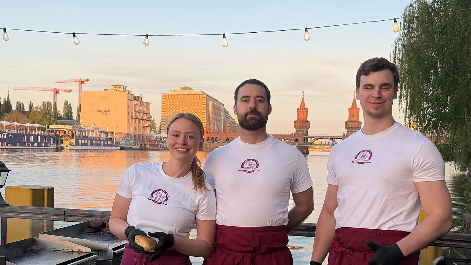 Die Crew hinter der Burger-Station am Spreeufer, Sonnenuntergang über der Oberbaumbrücke