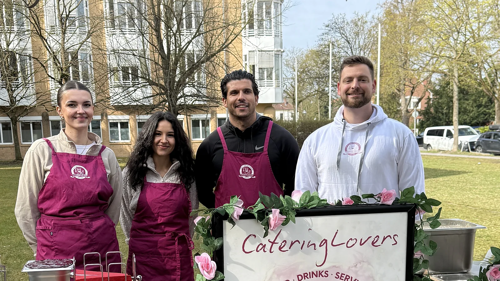 Vier Crew-Mitglieder hinter dem CateringLovers-Schild an der Station