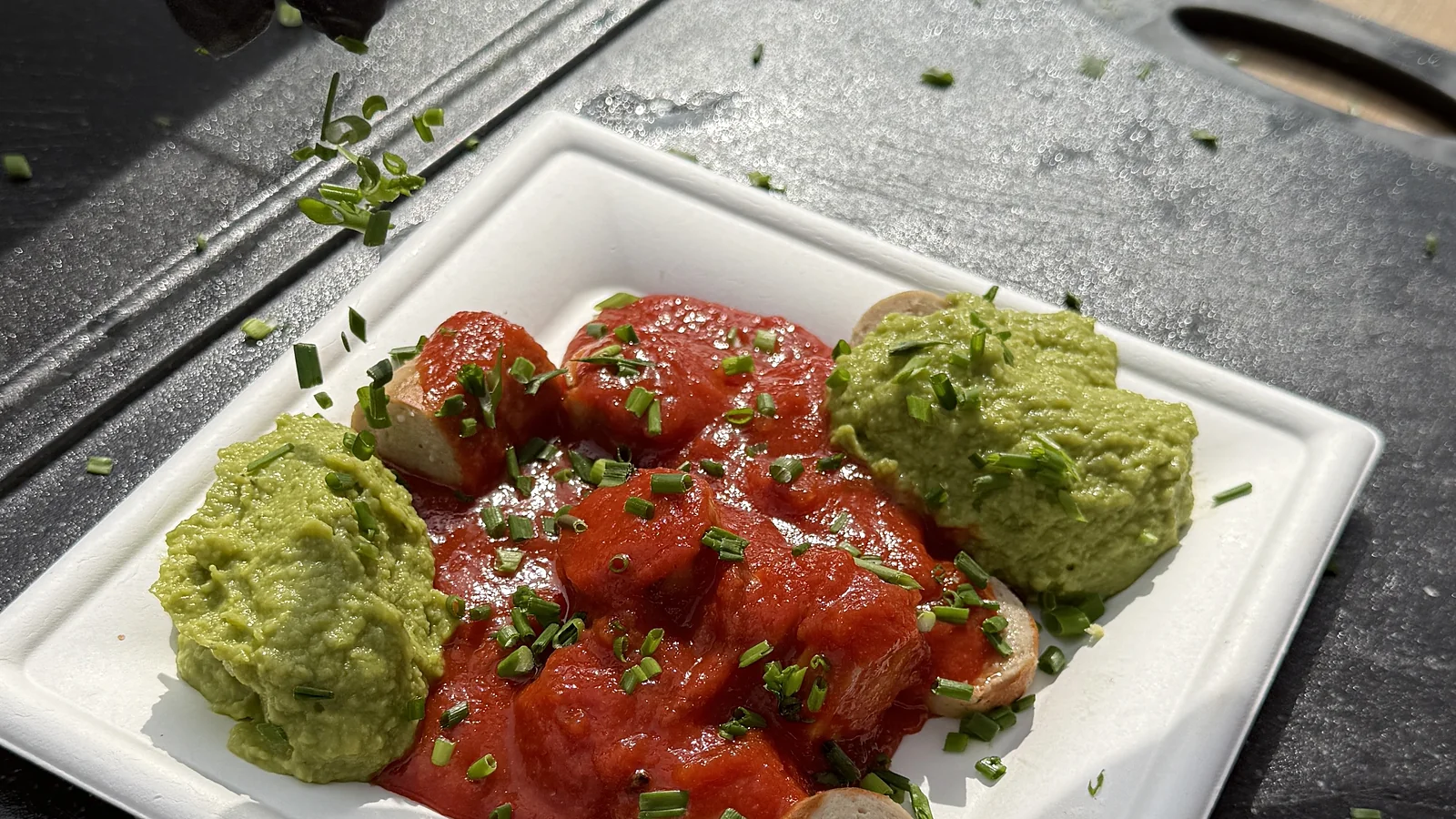 Currywurst mit Guacamole und frischem Schnittlauch, live angerichtet