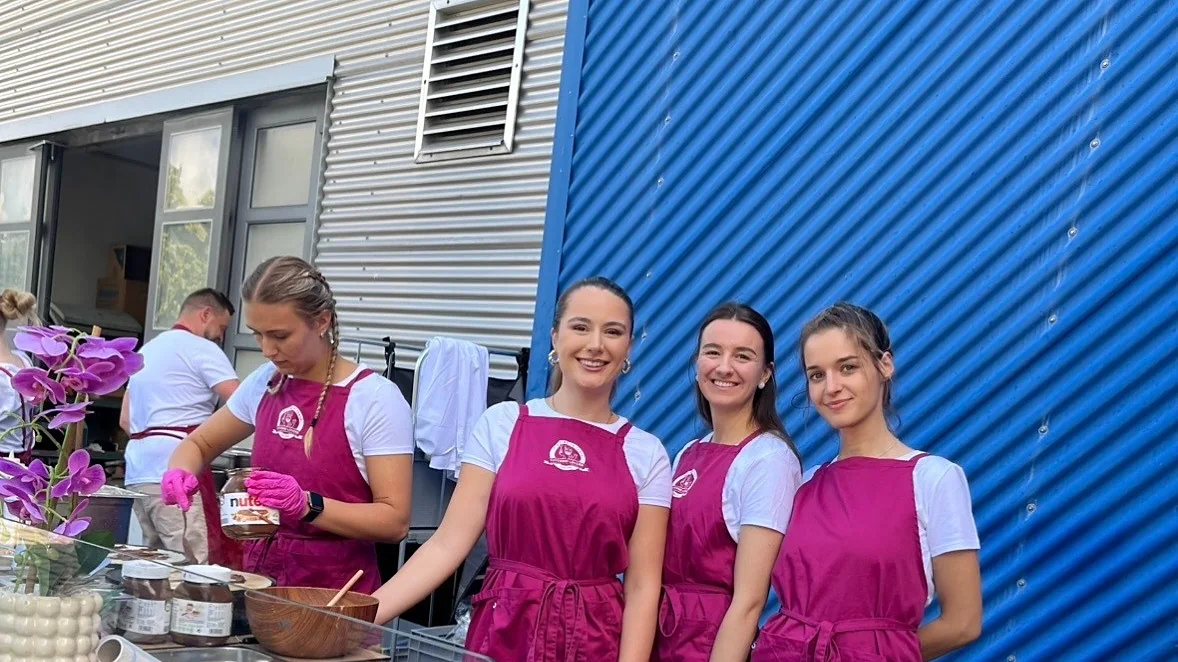 Vier Crew-Mitglieder an der Bowl-Station vor blauer Industriefassade