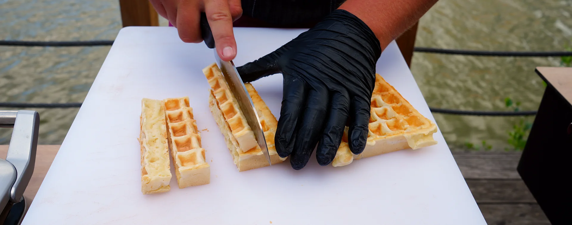 Messe-Catering: frisch gebackene Waffeln werden von Hand in Sticks geschnitten — Live-Cooking im Detail.