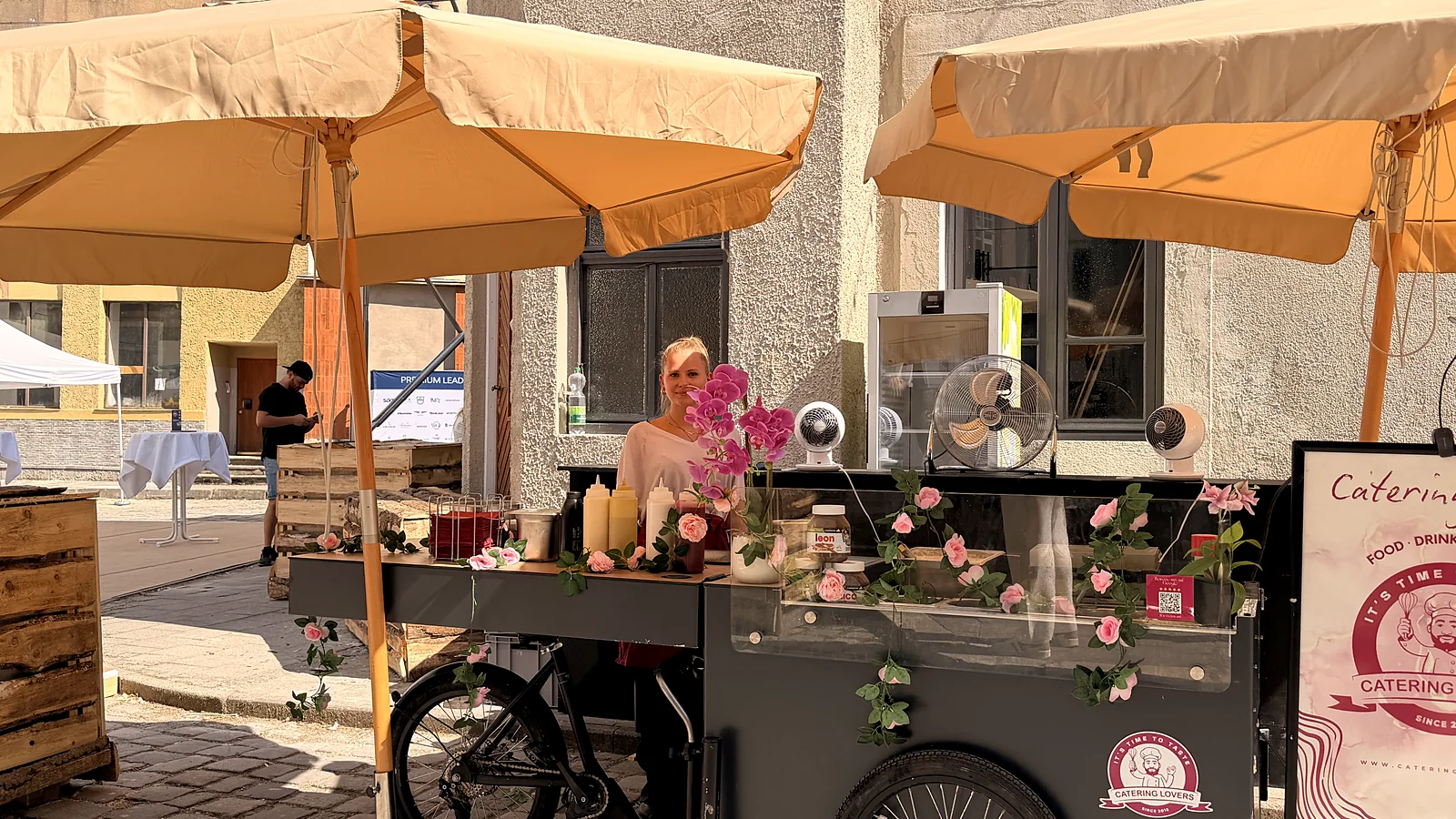 Blumengeschmücktes HappyBike unter Sonnenschirmen im Innenhof