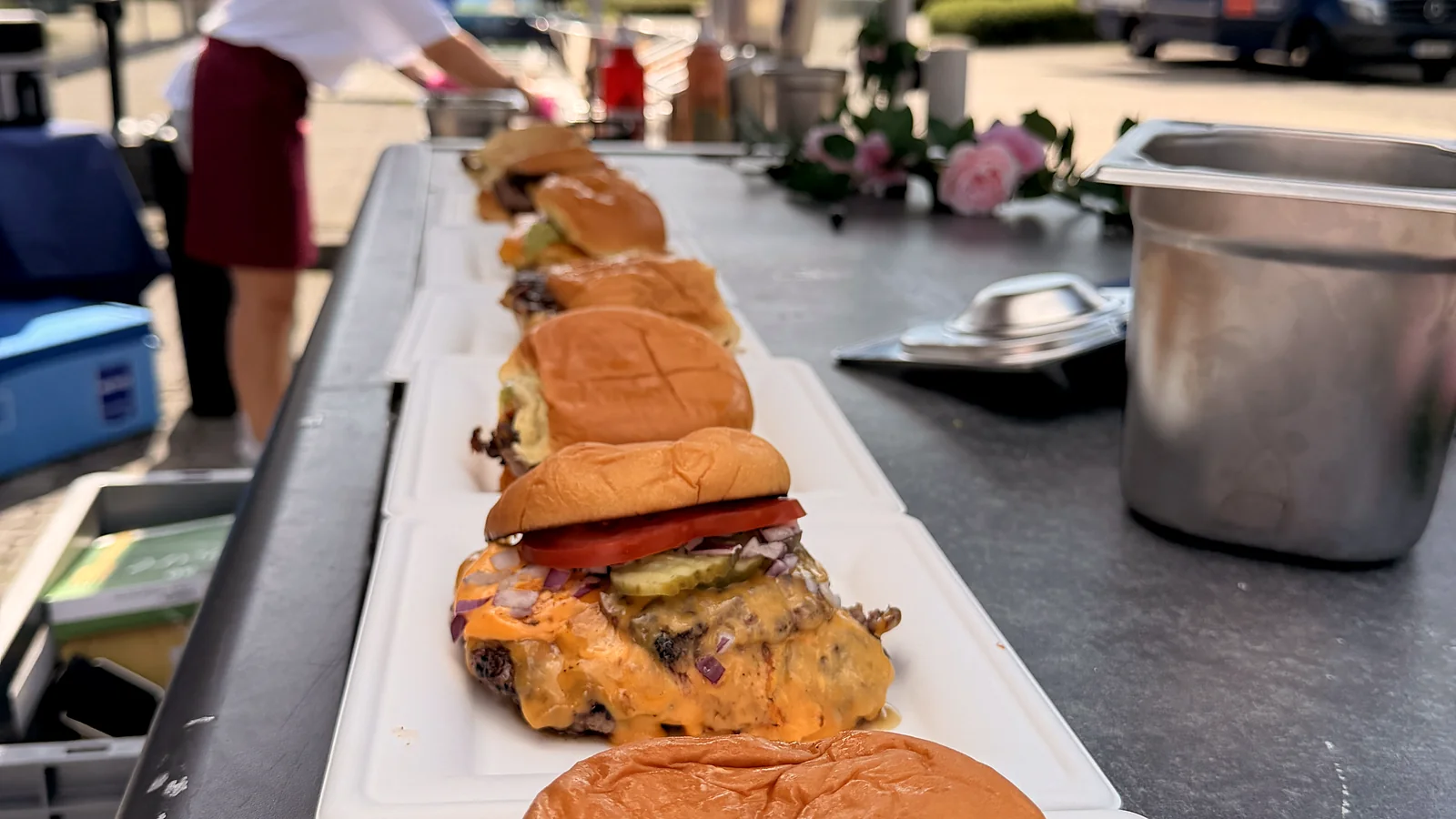 Frisch gebaute Burger in Reihe auf der Ausgabe der Live-Cooking-Station