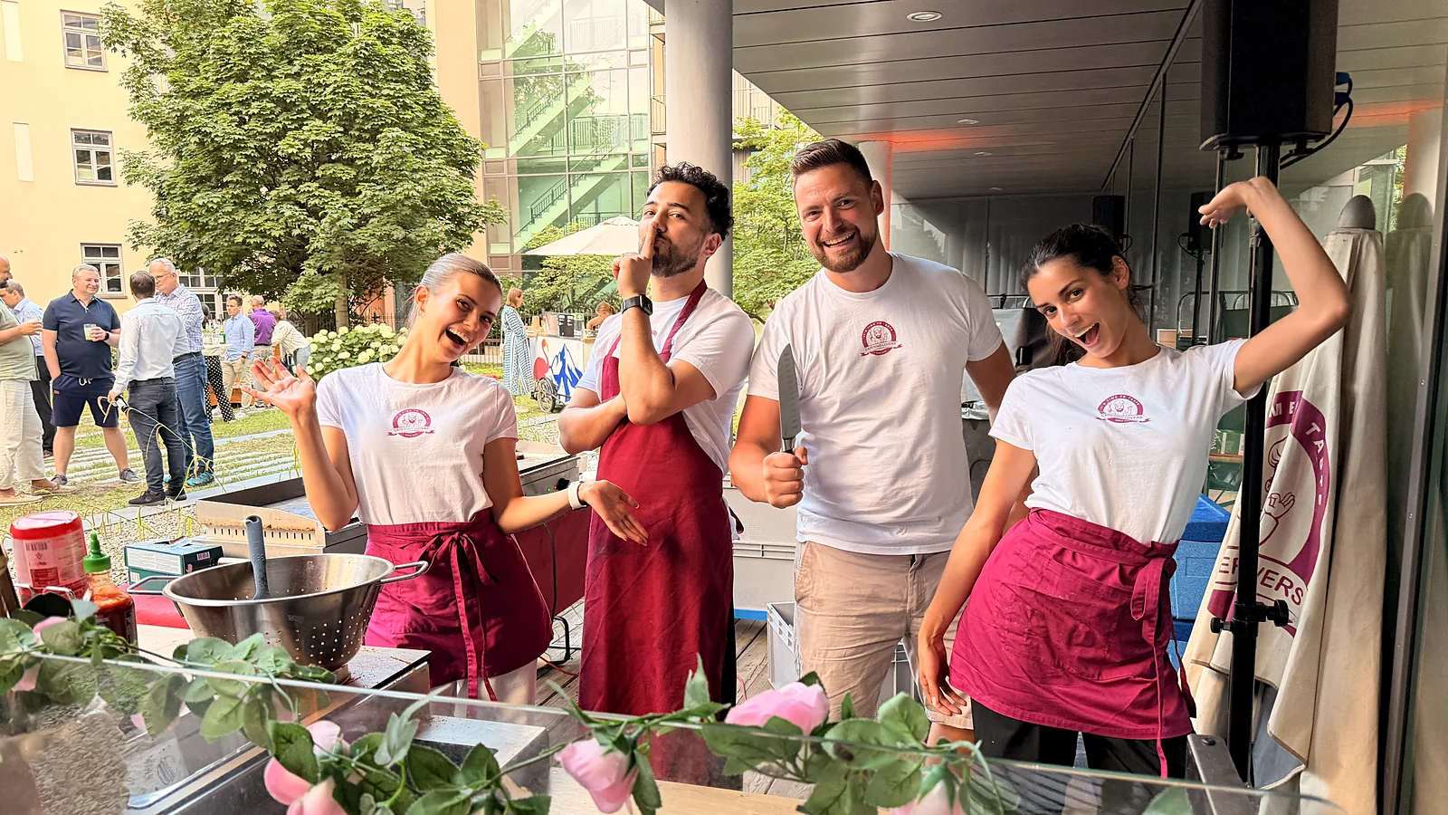 Vier Crew-Mitglieder lachen an der Station unter dem Vordach